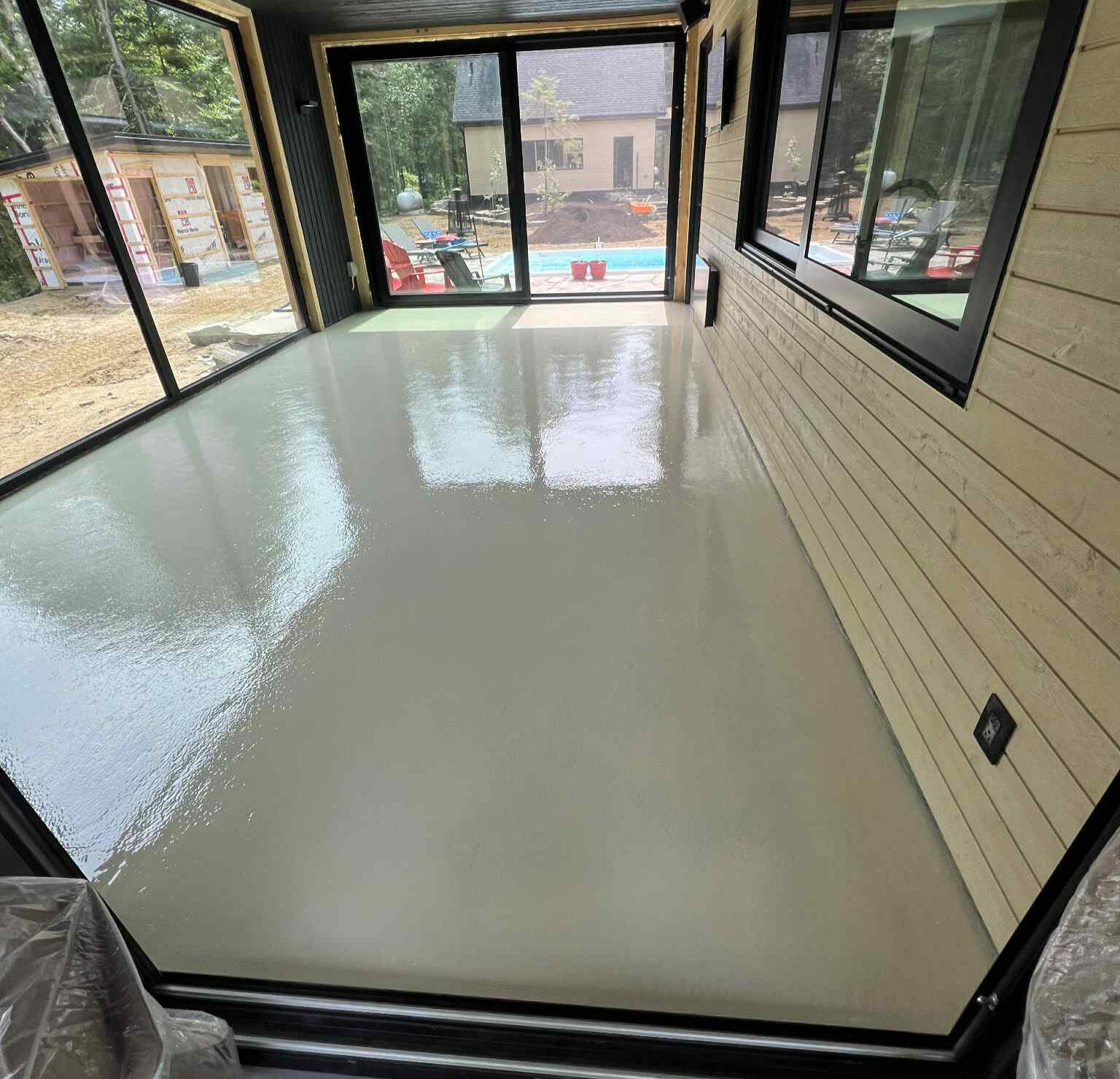 Plancher en époxy beige appliqué dans une pièce résidentielle, offrant une finition durable et facile d’entretien à Saint-Jérôme